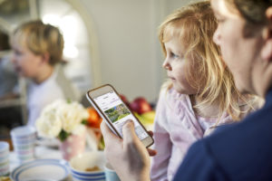 Young family looking at UK housing market adverts on mobile phone